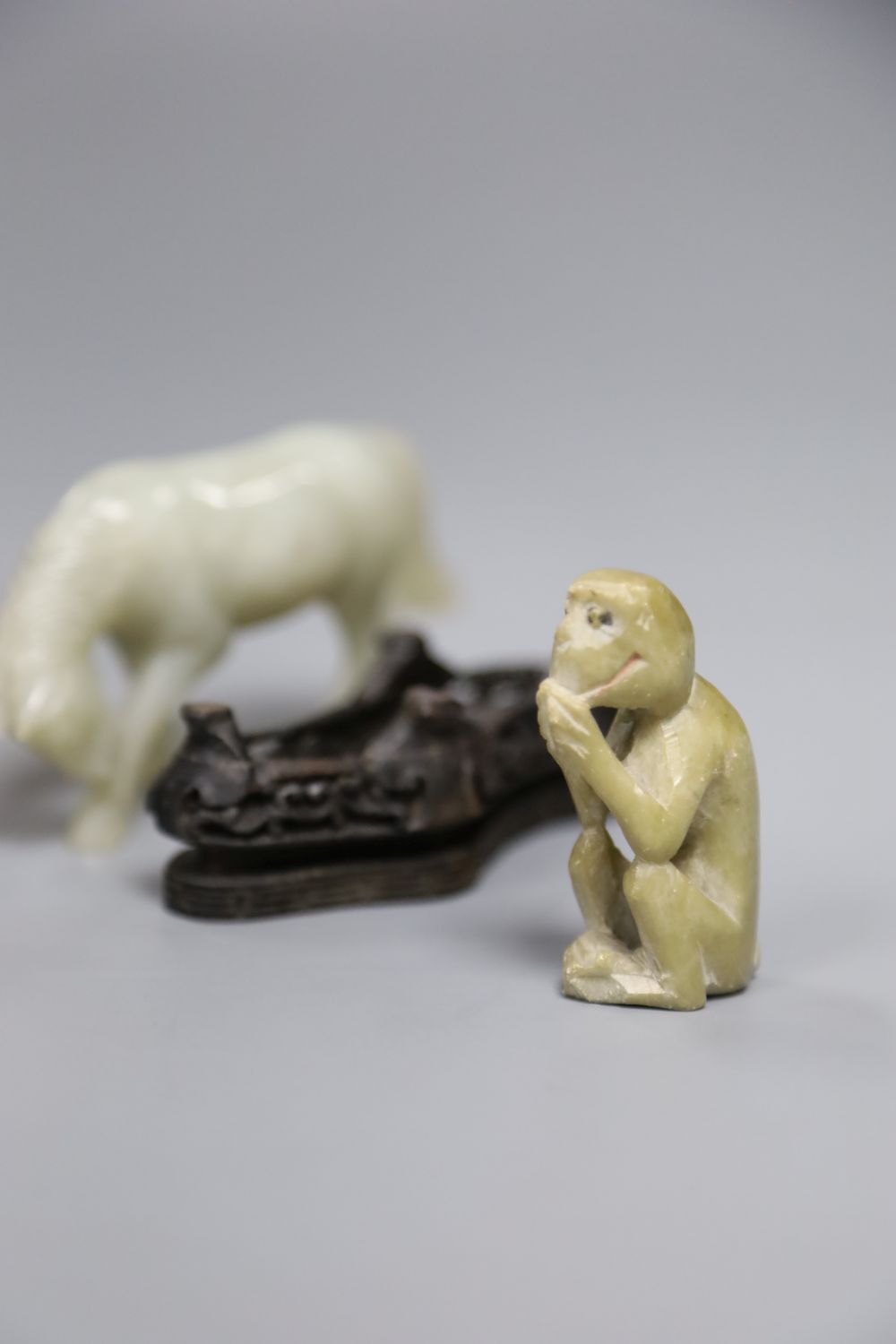 A Chinese jade figure of a buffalo, a hardstone horse and carp and a soapstone monkey